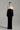 Black velvet column gown with sculpted white silk roses and an off-shoulder neckline - IHF STUDIO