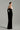 Black velvet column gown with sculpted white silk roses and an off-shoulder neckline - IHF STUDIO
